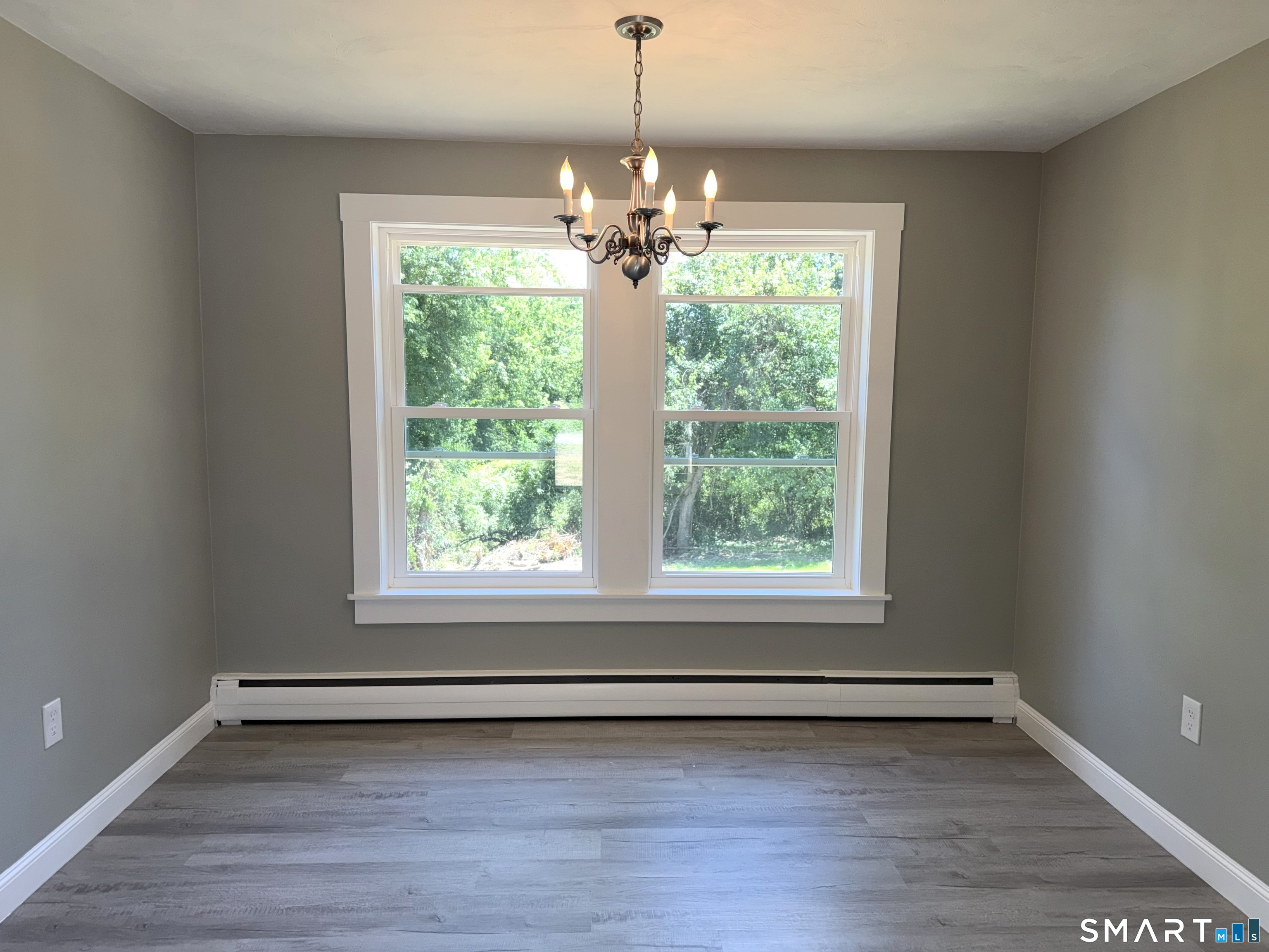 341 Harland Road Norwich, CT 06360 - Photo 7 of 29 a view of an empty room with wooden floor and a window