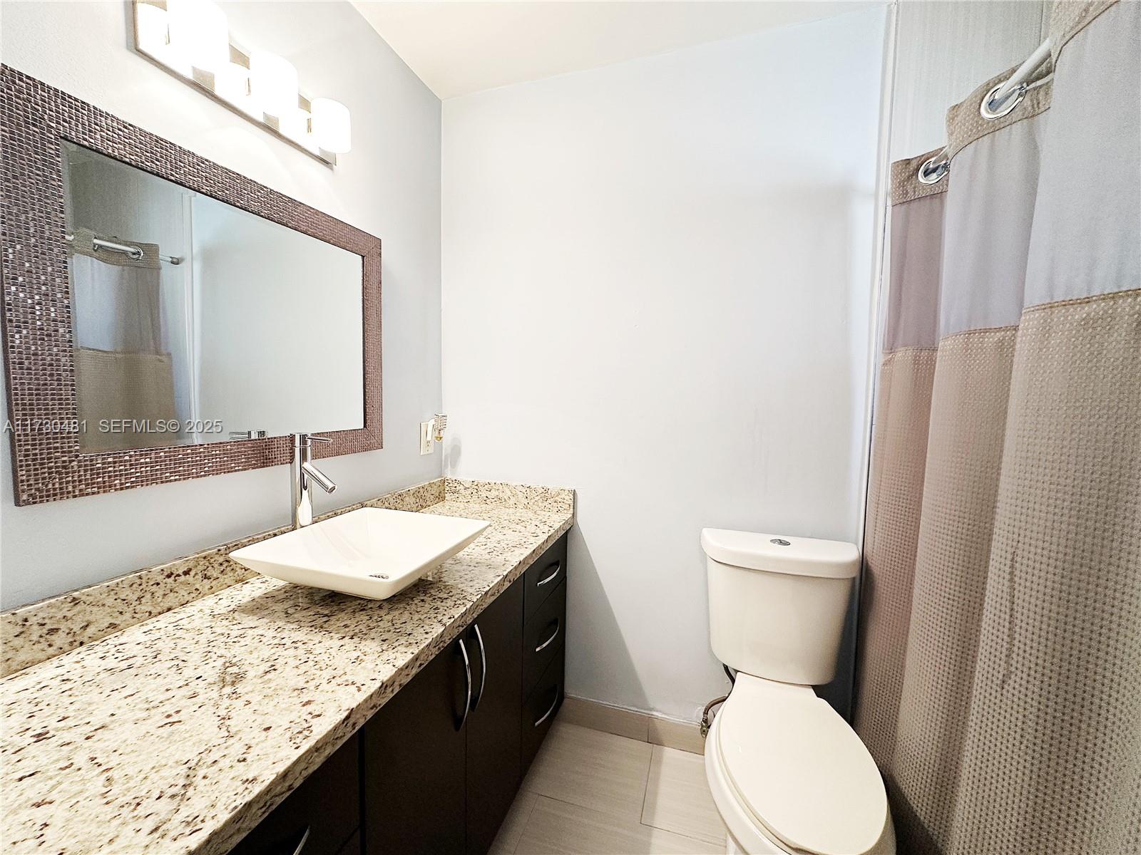 8550 Southwest 109th Avenue, Unit 5217 Miami, FL 33173 - Photo 11 of 16 a bathroom with a granite countertop sink toilet and shower