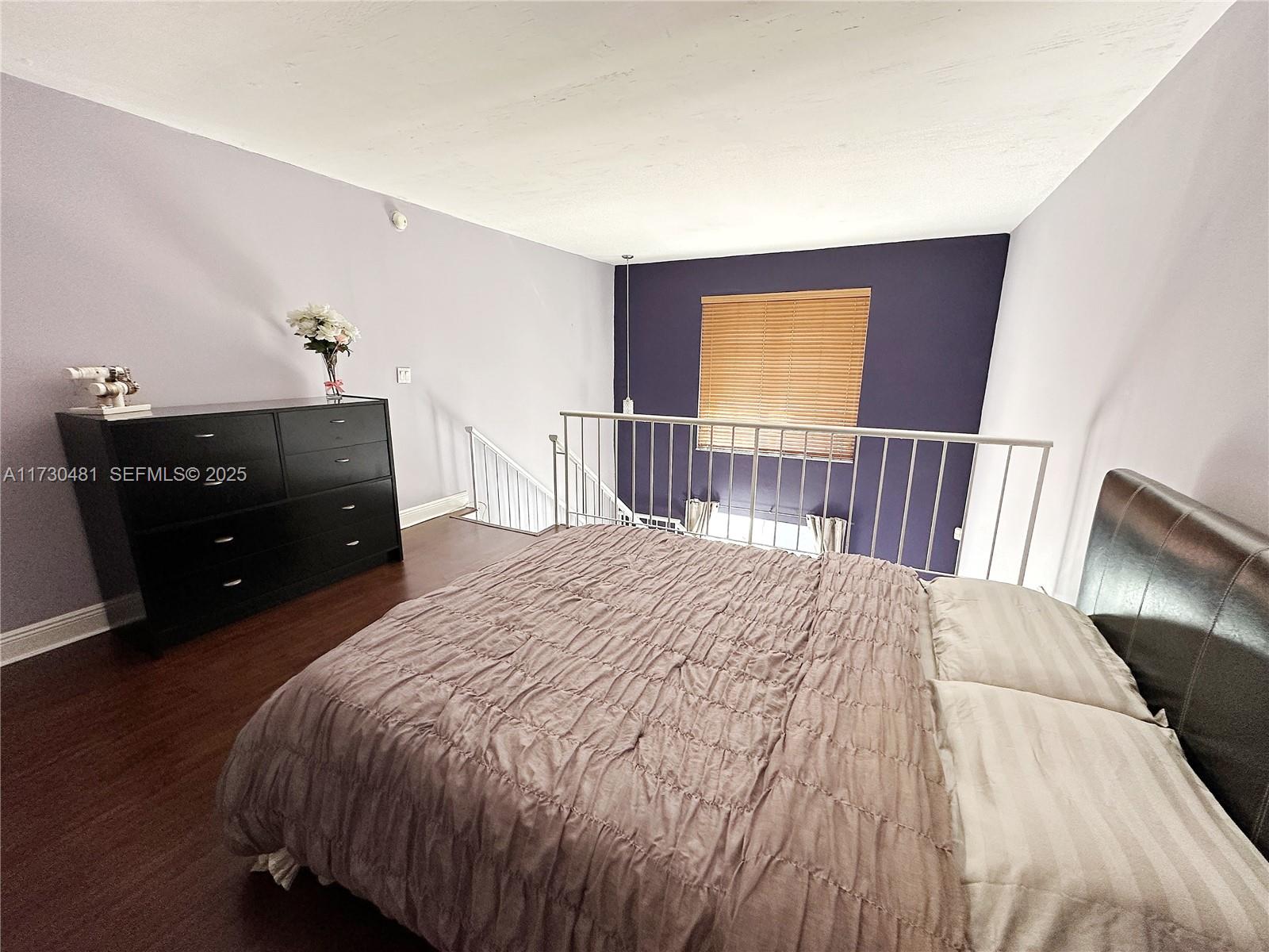 8550 Southwest 109th Avenue, Unit 5217 Miami, FL 33173 - Photo 8 of 16 a bedroom with a bed and wooden floor