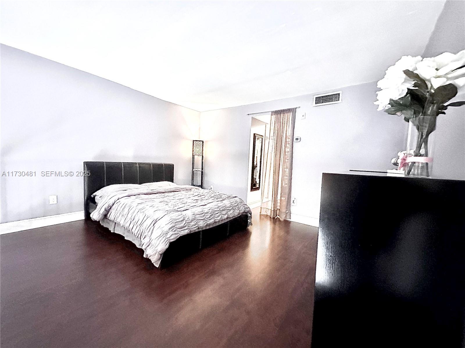 8550 Southwest 109th Avenue, Unit 5217 Miami, FL 33173 - Photo 9 of 16 a bedroom with a bed table and a potted plant