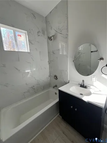 a bathroom with a tub sink and mirror