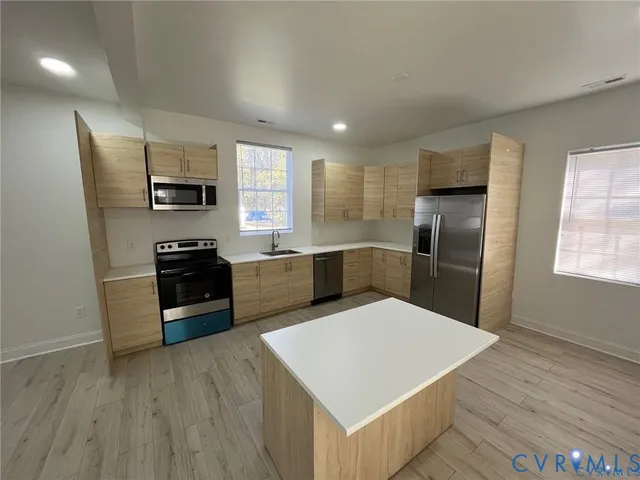 a kitchen with stainless steel appliances a refrigerator sink and stove