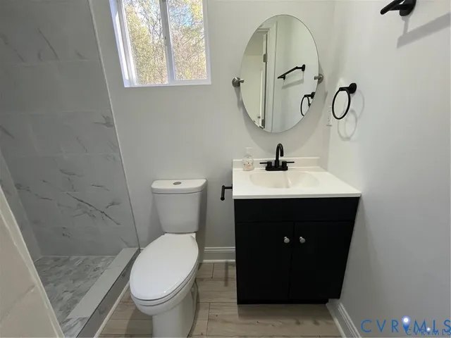 a bathroom with a sink and mirror with toilet
