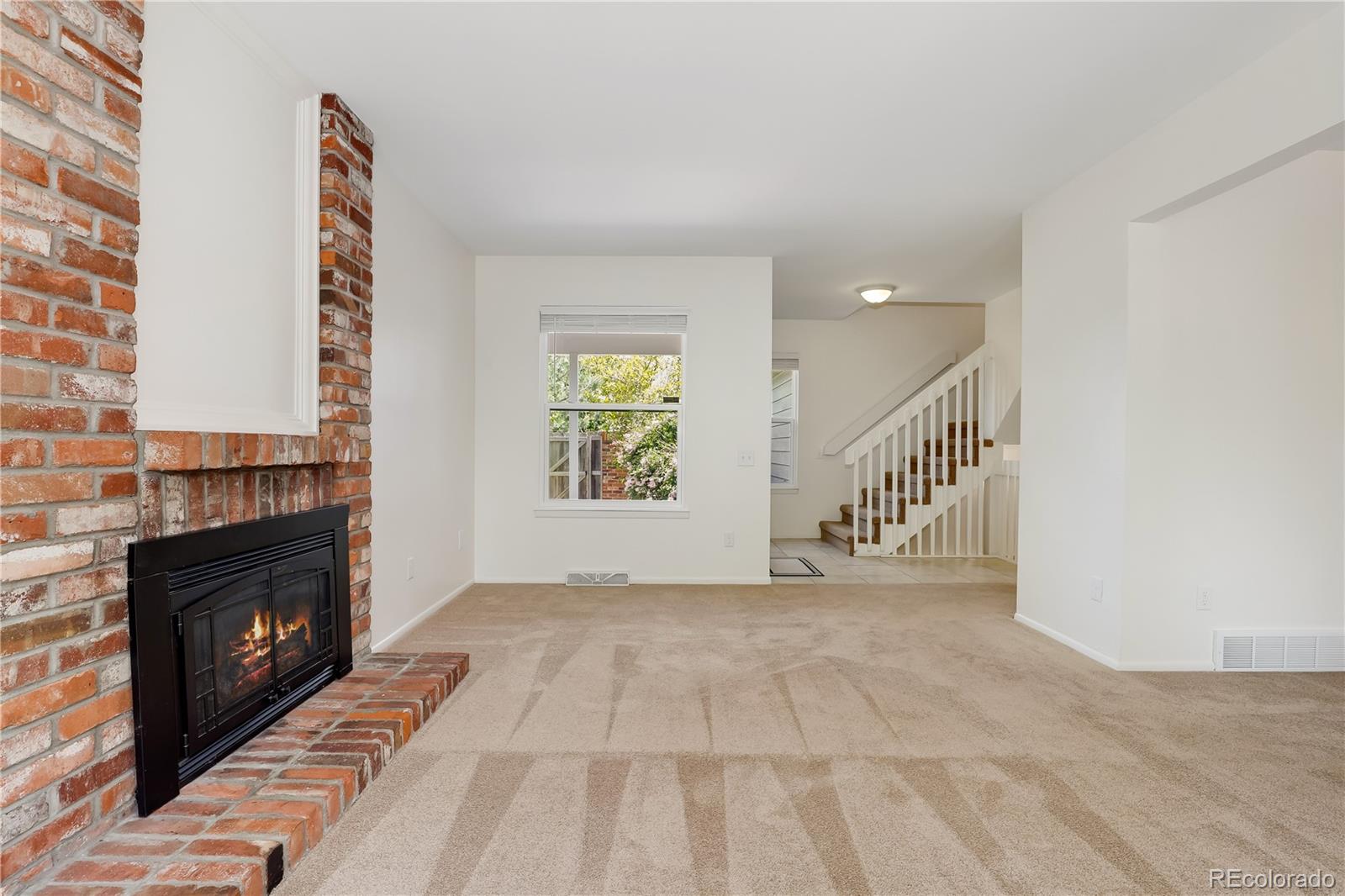 8760 Independence Way Arvada, CO 80005 - Photo 12 of 40 a view of an empty room with stairs and a fireplace