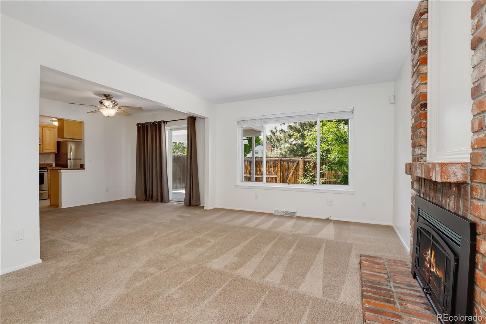 8760 Independence Way Arvada, CO 80005 - Photo 13 of 40 a view of an empty room with a fireplace and a window