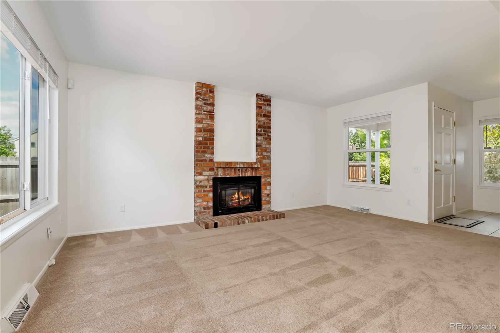 8760 Independence Way Arvada, CO 80005 - Photo 15 of 40 an empty room with windows and fireplace