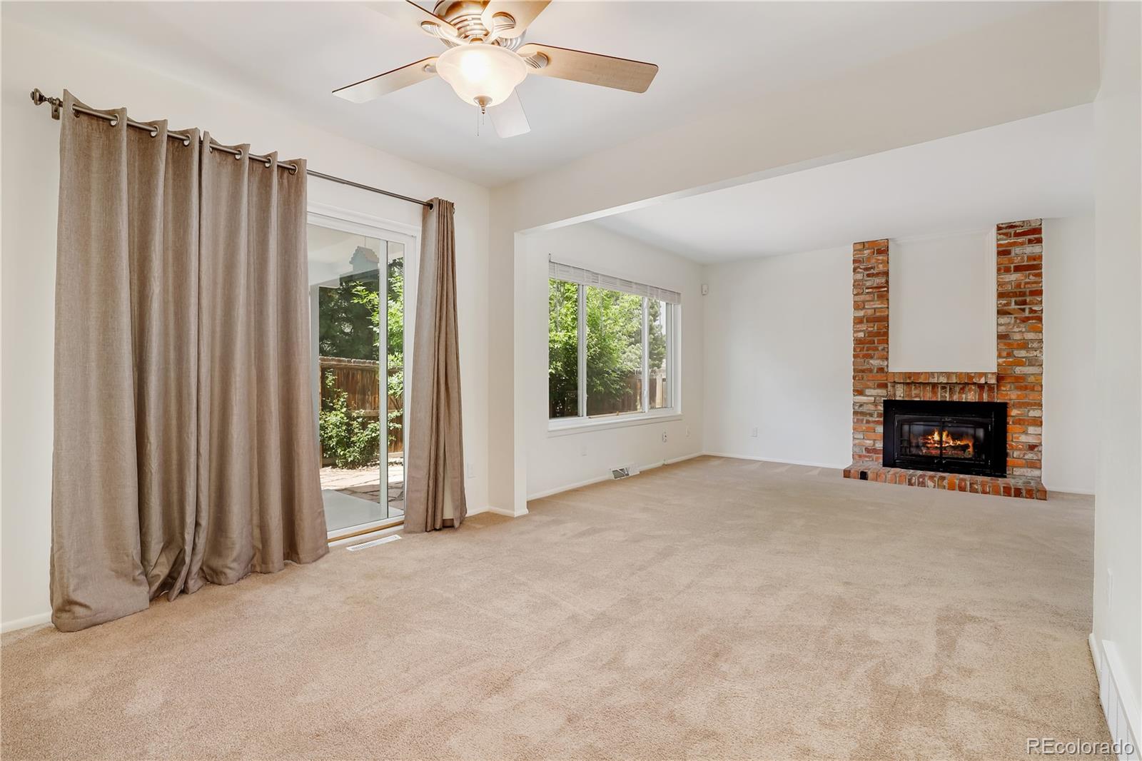 8760 Independence Way Arvada, CO 80005 - Photo 17 of 40 an empty room with windows fireplace and fan