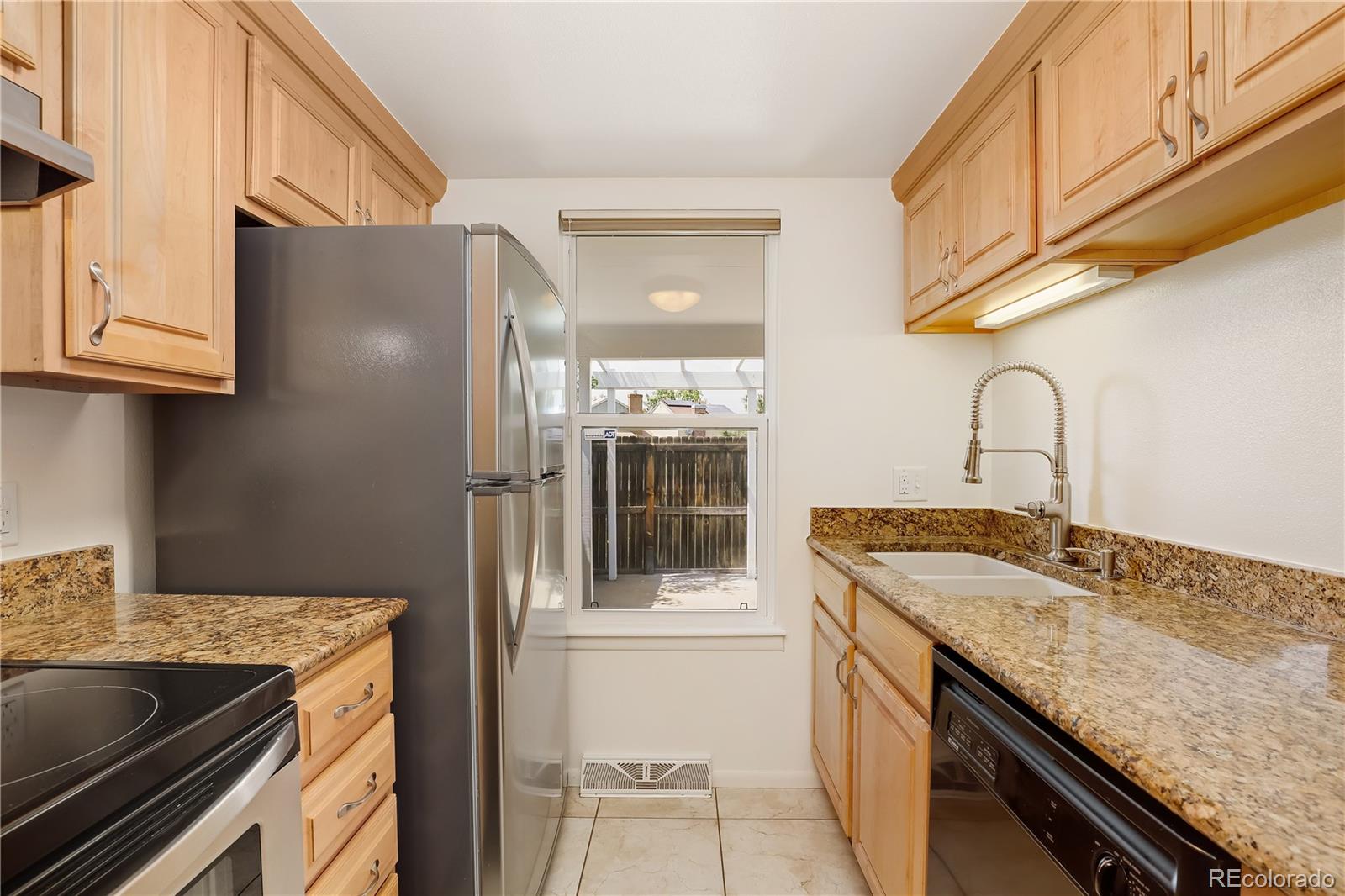 8760 Independence Way Arvada, CO 80005 - Photo 20 of 40 a kitchen with a granite countertop sink stainless steel appliances and cabinets