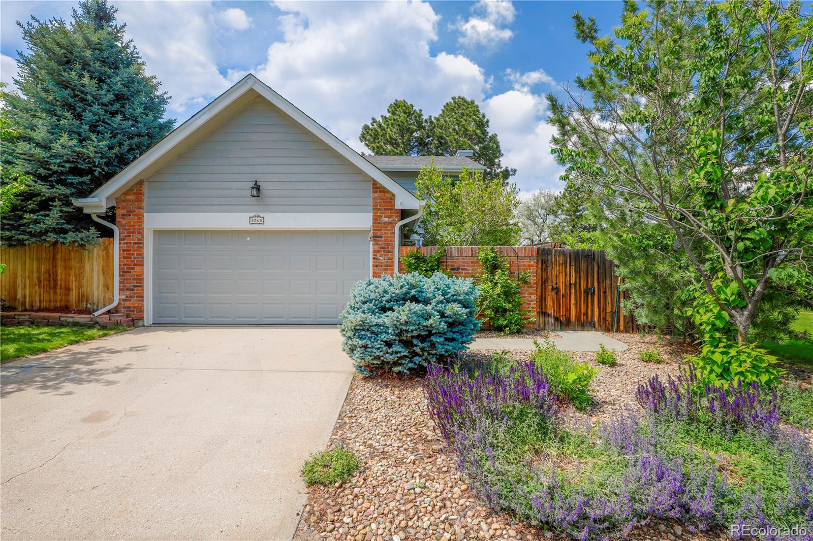 8760 Independence Way Arvada, CO 80005 - Photo 2 of 40 a front view of a house with a yard and a garage