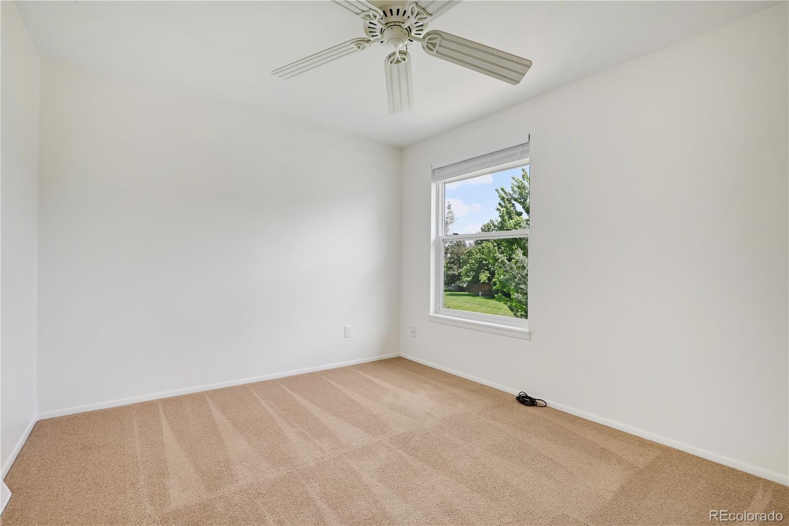 8760 Independence Way Arvada, CO 80005 - Photo 25 of 40 an empty room with a window and a fan