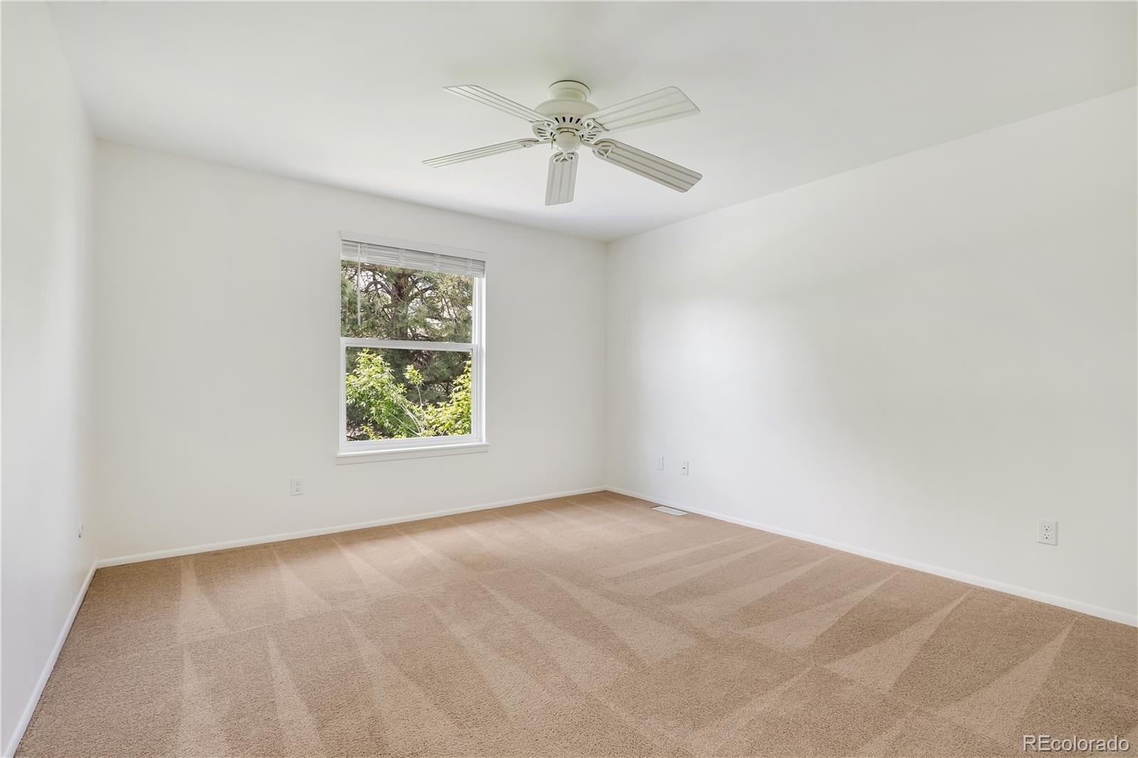 8760 Independence Way Arvada, CO 80005 - Photo 26 of 40 an empty room with a window and a ceiling fan