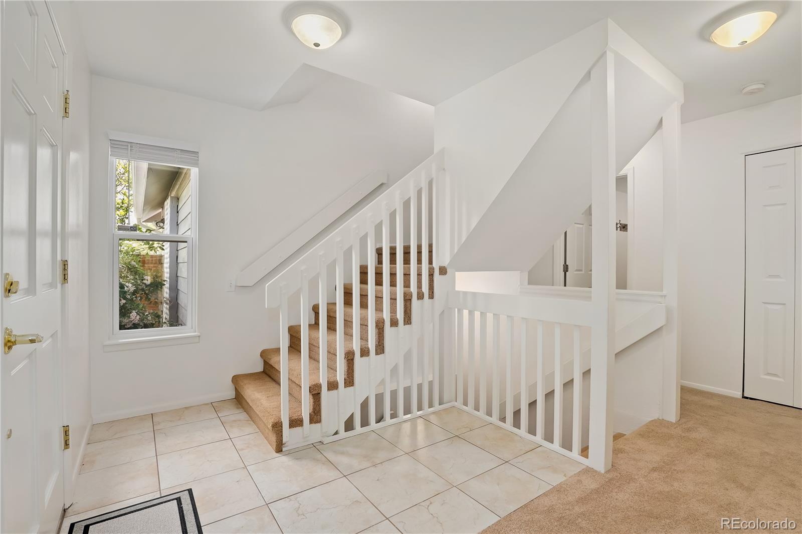 8760 Independence Way Arvada, CO 80005 - Photo 10 of 40 a view of entryway with stairs and a floor to ceiling window