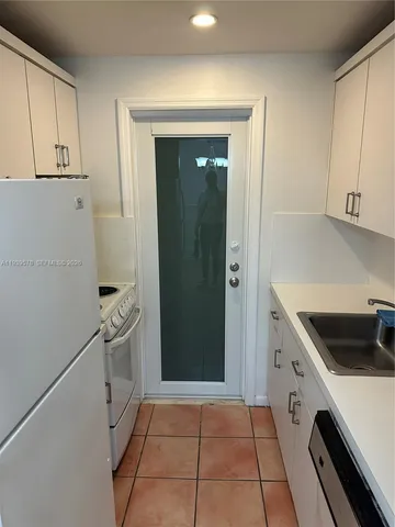 a kitchen with a refrigerator sink and cabinets
