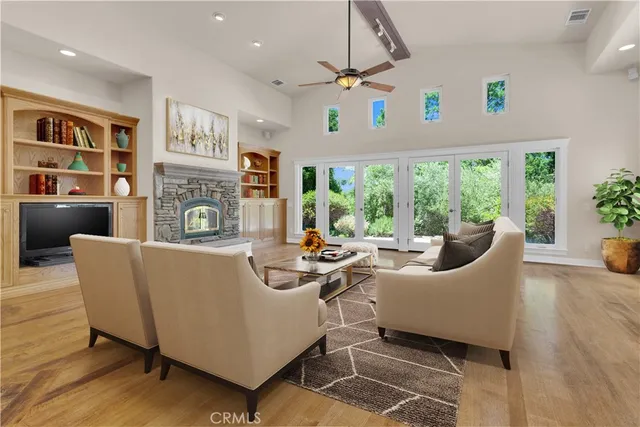 a living room with fireplace furniture and a large window