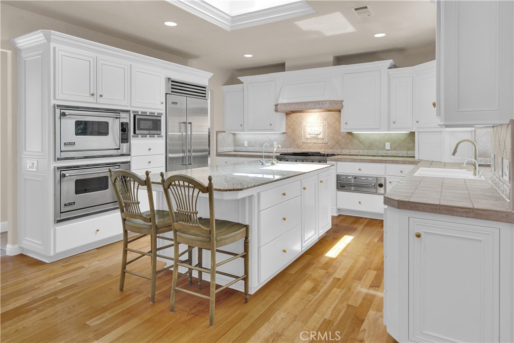 117 Frontier Way Templeton, CA 93465 - Photo 5 of 60 a kitchen with stainless steel appliances granite countertop a stove top oven a sink dishwasher and a refrigerator with wooden floor