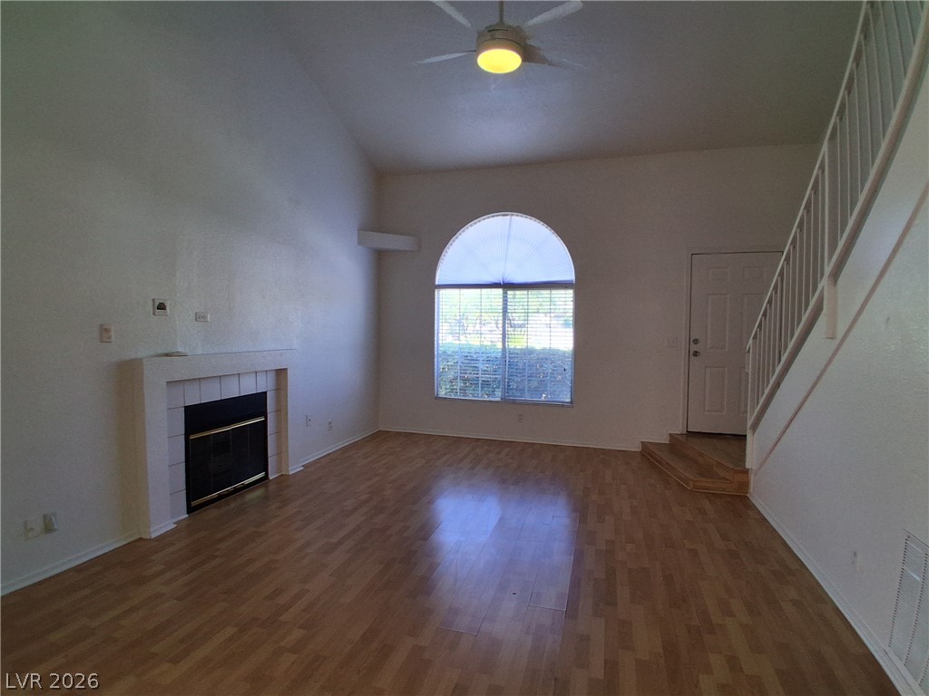 8023 Simone Avenue Las Vegas, NV 89147 - Photo 2 of 12 Step into a sun-filled living area featuring a cozy fireplace and attractive wood flooring.