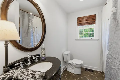 a bathroom with a toilet a sink and mirror