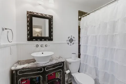 a bathroom with a toilet sink and mirror