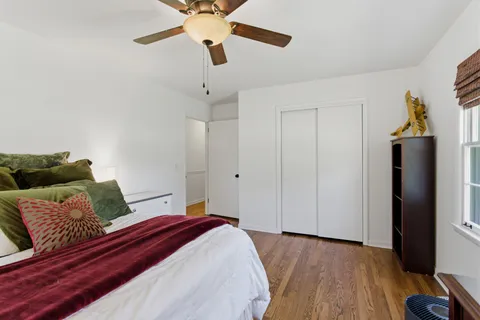 a bedroom with a bed chandelier and a window