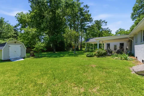 a front view of a house with a yard and trees