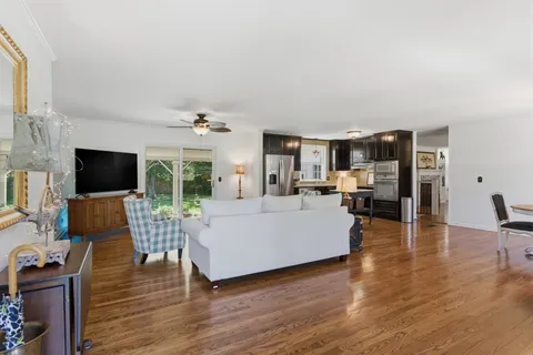 a living room with furniture a flat screen tv and a large window