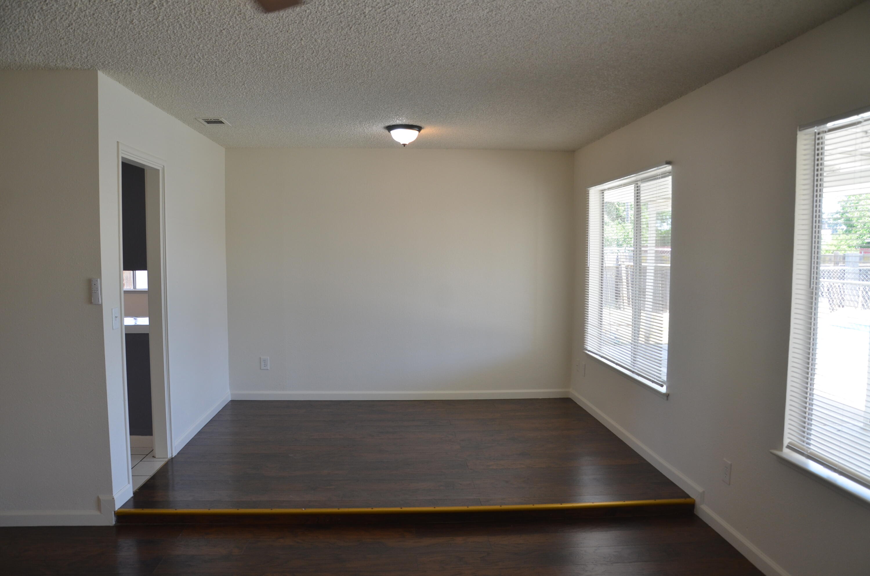 339 West Spring Lane Lemoore, CA 93245 - Photo 6 of 31 an empty room with wooden floor and windows