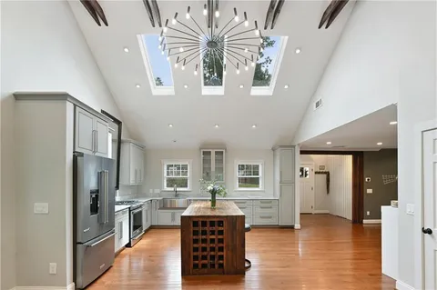 a kitchen with a dining table chairs cabinets and stainless steel appliances