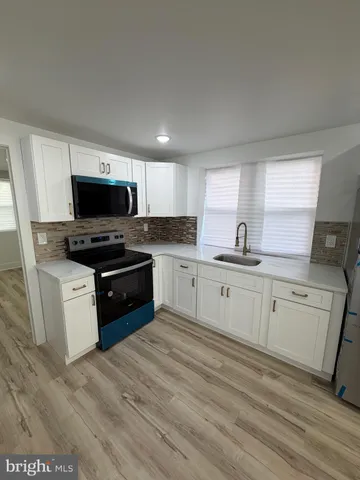 a kitchen with sink a microwave and cabinets
