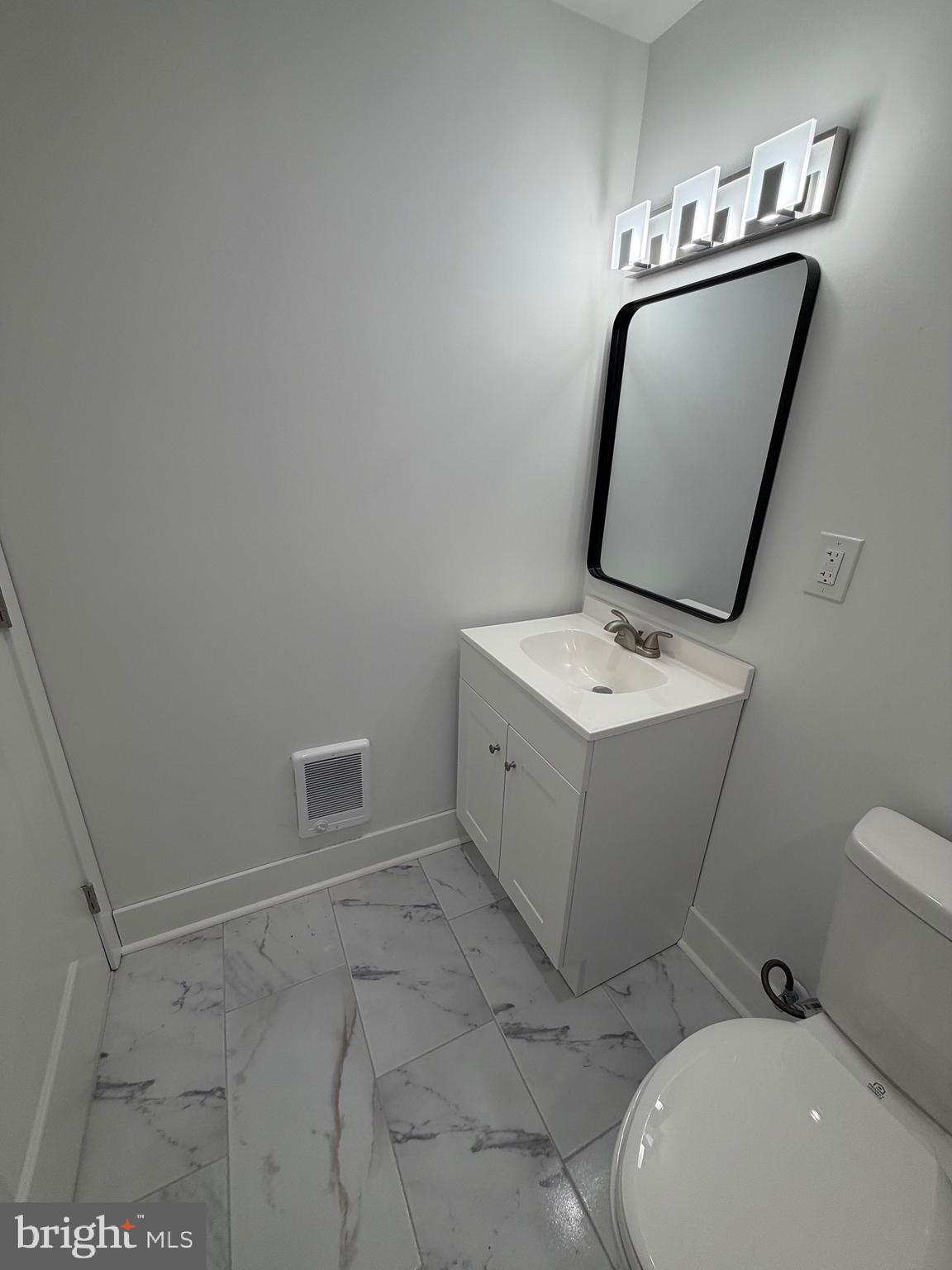 7810 Limekiln Pike, Unit 1 Philadelphia, PA 19150 - Photo 9 of 16 a bathroom with a toilet sink and mirror