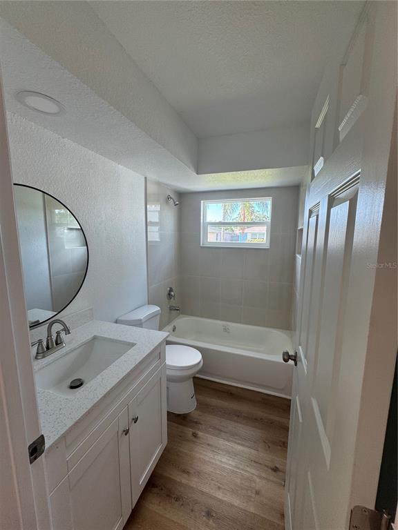 9901 Aquarius Drive, Unit 3 Port Richey, FL 34668 - Photo 11 of 23 a bathroom with a double vanity sink toilet mirror and bathtub