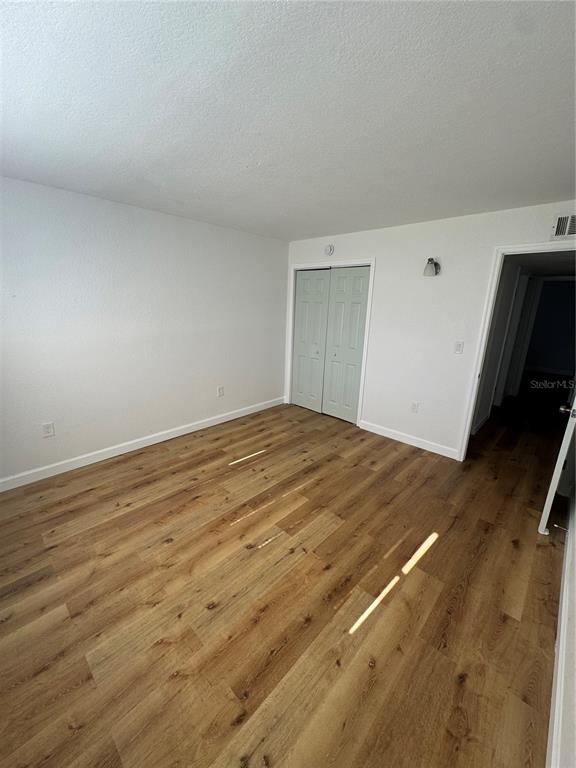 9901 Aquarius Drive, Unit 3 Port Richey, FL 34668 - Photo 9 of 23 a view of empty room with wooden floor