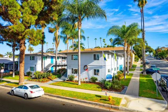 a front view of a house with garden and trees
