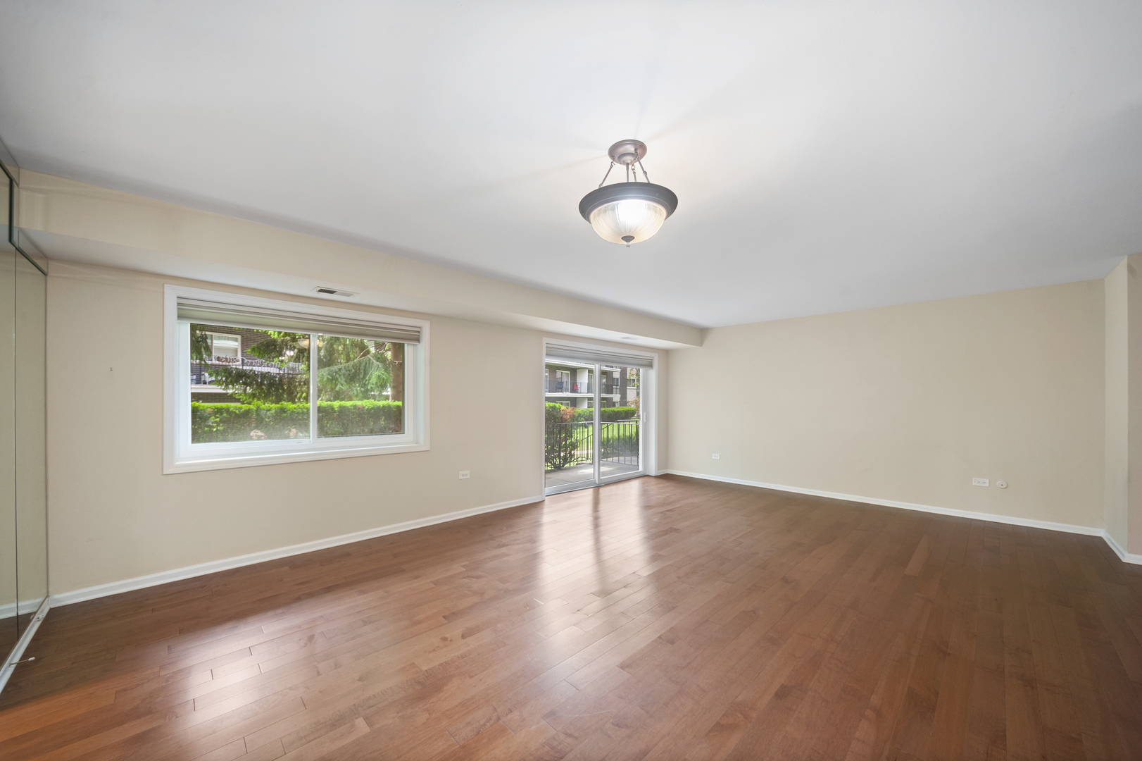 4949 Golf Road, Unit 101 Skokie, IL 60077 - Photo 17 of 22 an empty room with wooden floor and windows