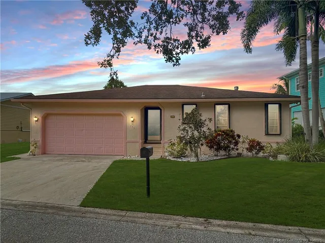 a front view of a house with a garden and yard