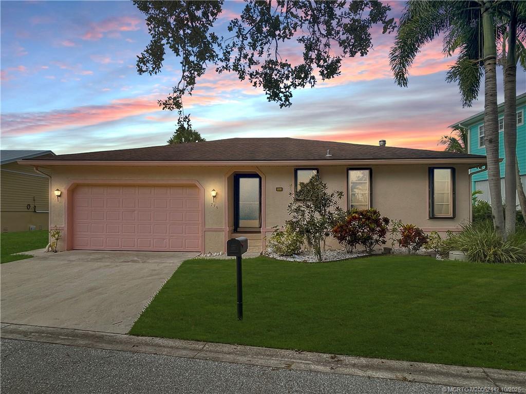 a front view of a house with a garden and yard
