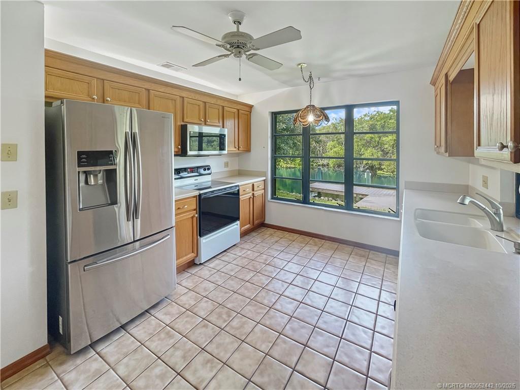 735 Southwest Salerno Road Stuart, FL 34997 - Photo 11 of 27 a kitchen with stainless steel appliances granite countertop a refrigerator and a sink