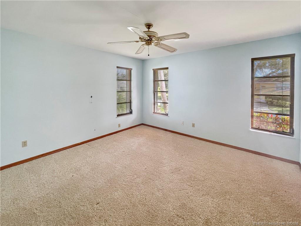 735 Southwest Salerno Road Stuart, FL 34997 - Photo 17 of 27 an empty room with a ceiling fan and window