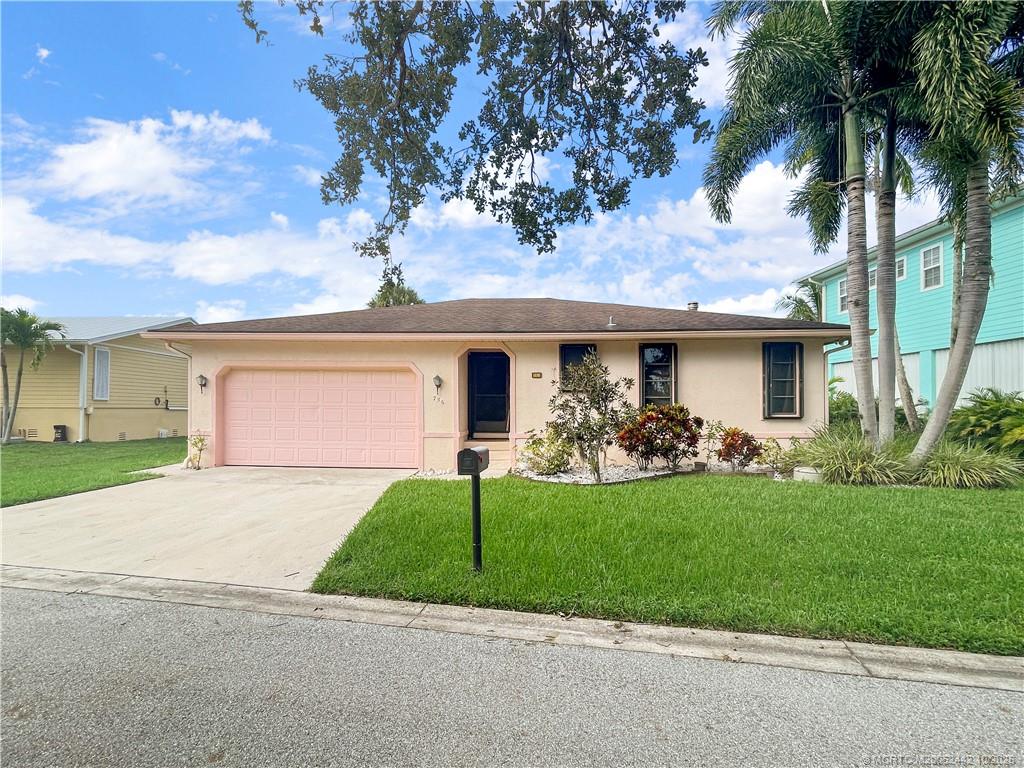 735 Southwest Salerno Road Stuart, FL 34997 - Photo 4 of 27 a front view of a house with a yard and garage