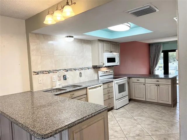 a kitchen with a sink stove and microwave