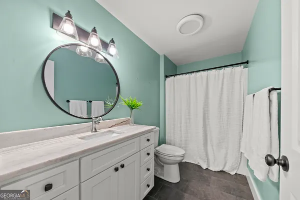 a bathroom with a granite countertop sink and a mirror