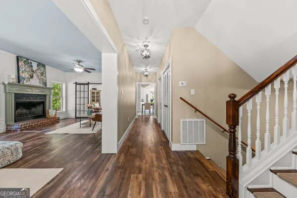 a view of a livingroom with wooden floor and staircase