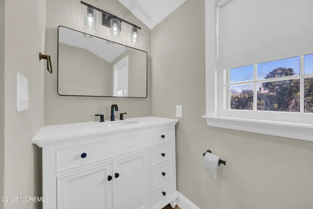 a bathroom with a sink vanity and a mirror