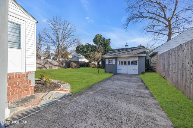 a view of a house with a yard and large tree