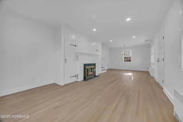 a view of empty room with wooden floor and fireplace