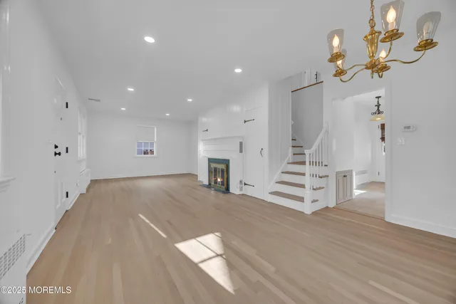 a view of a livingroom with wooden floor and staircase