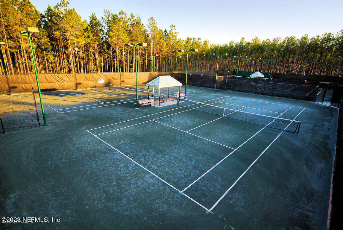 212 Twining Trace St. Johns, FL 32259 - Photo 53 of 60 a view of a tennis ground with large trees