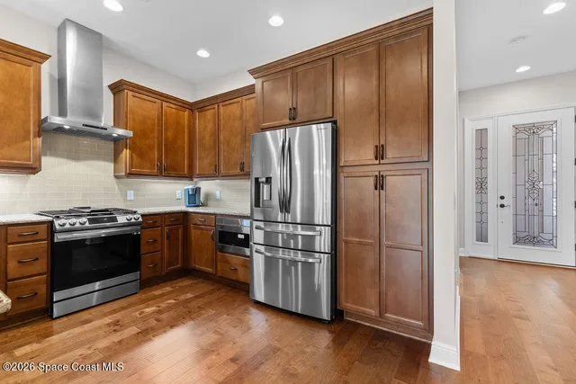 a kitchen with stainless steel appliances granite countertop a refrigerator a sink and a stove