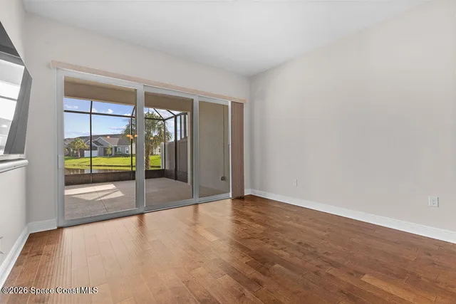 a view of a living room with hardwood floor and a flat screen tv