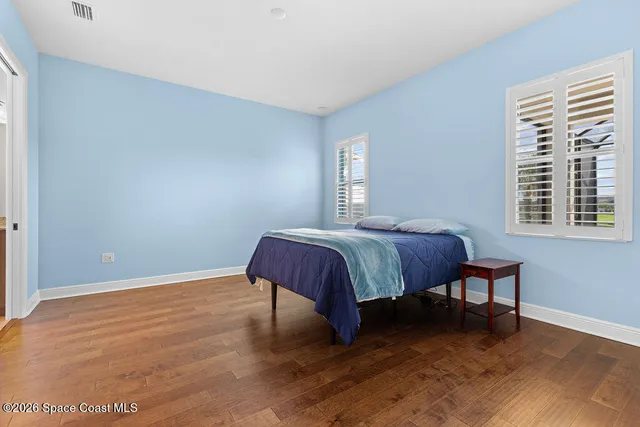 a view of a room with wooden floor and a kitchen