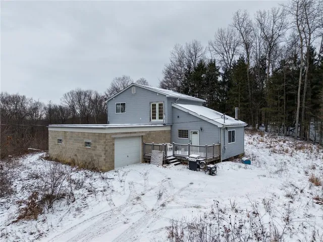 a view of a backyard with a large tree and wooden fence